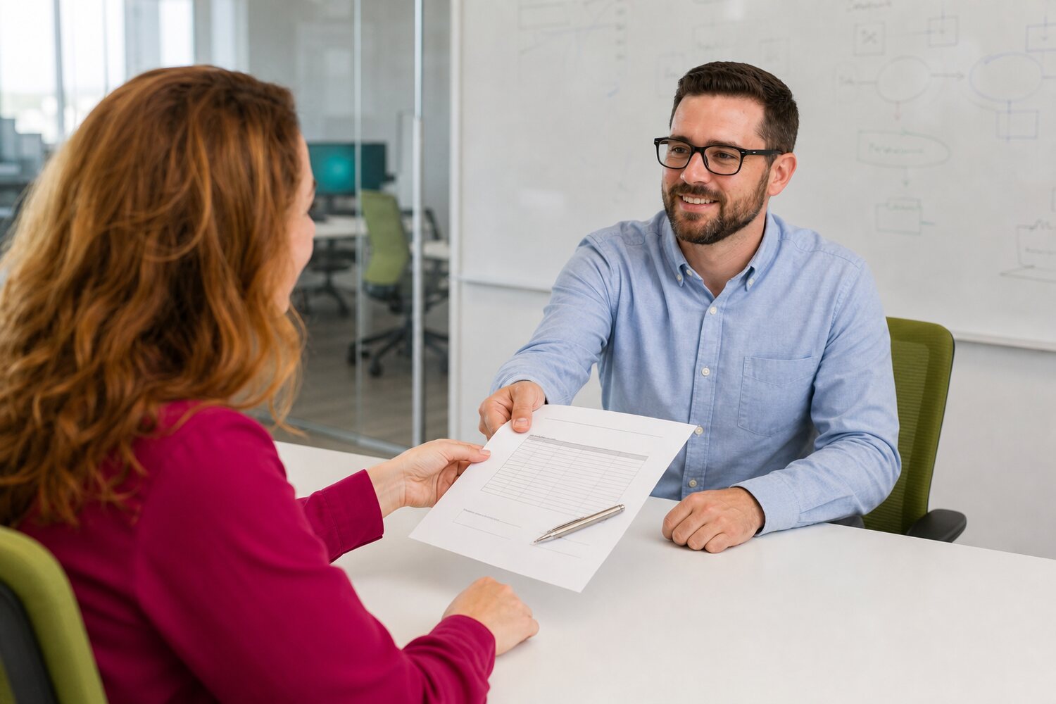 Consultant handing a printed commitment document across the table to a client