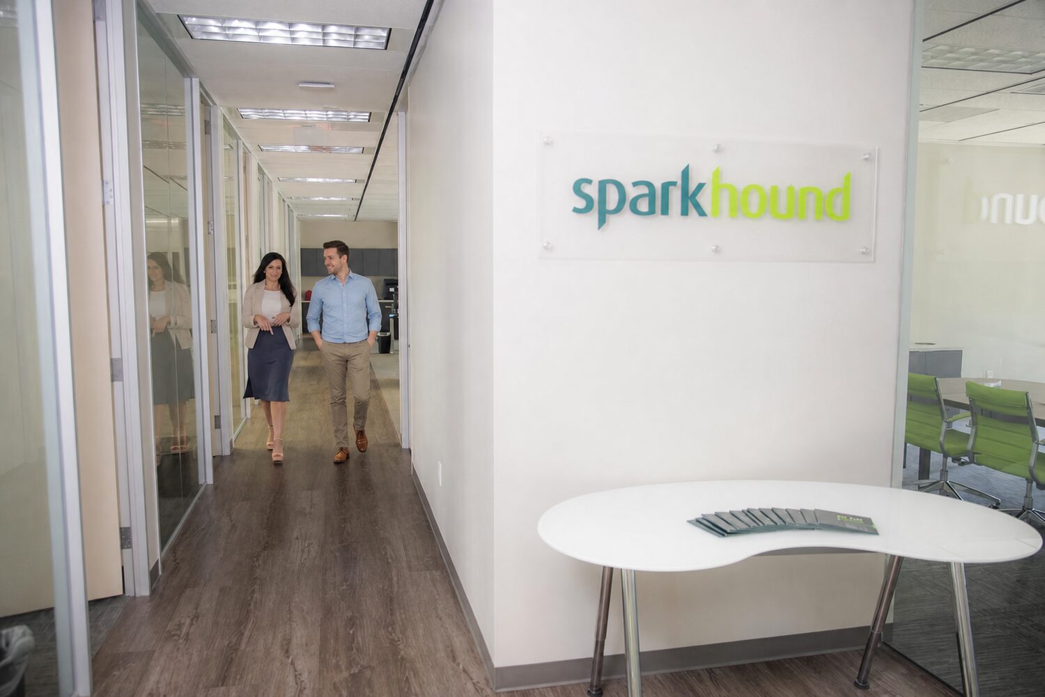 Two Sparkhound team members walking and talking in the Sparkhound office hallway