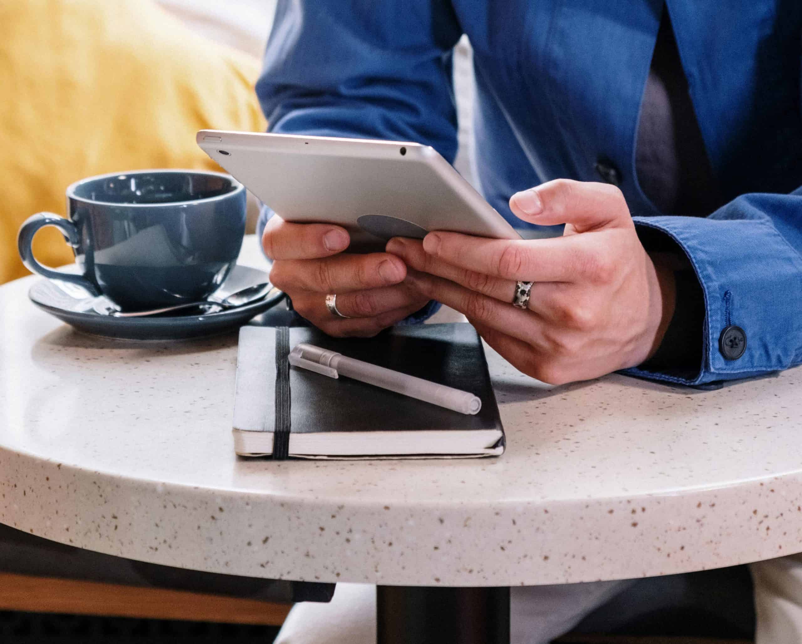 Man looking at an iPad in a coffee shop