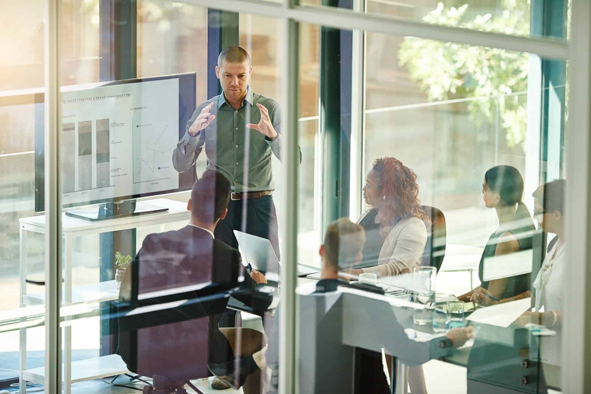 Group sitting in a glass window meeting room